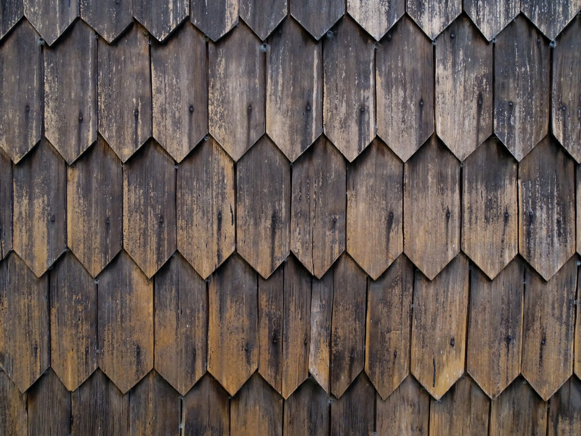 Weathered wooden shingles forming a repeating geometric pattern