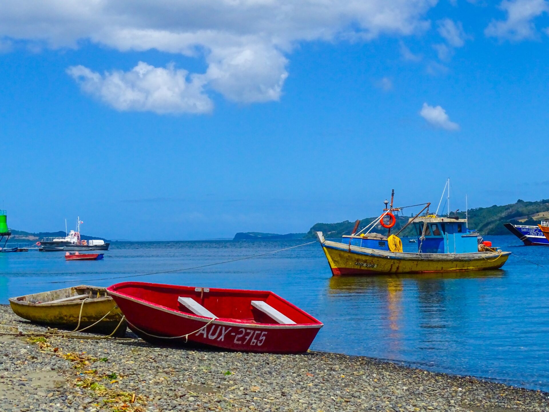 Fishing boats anchored in the calm waters of Quemchi, Chiloé Island, Chile