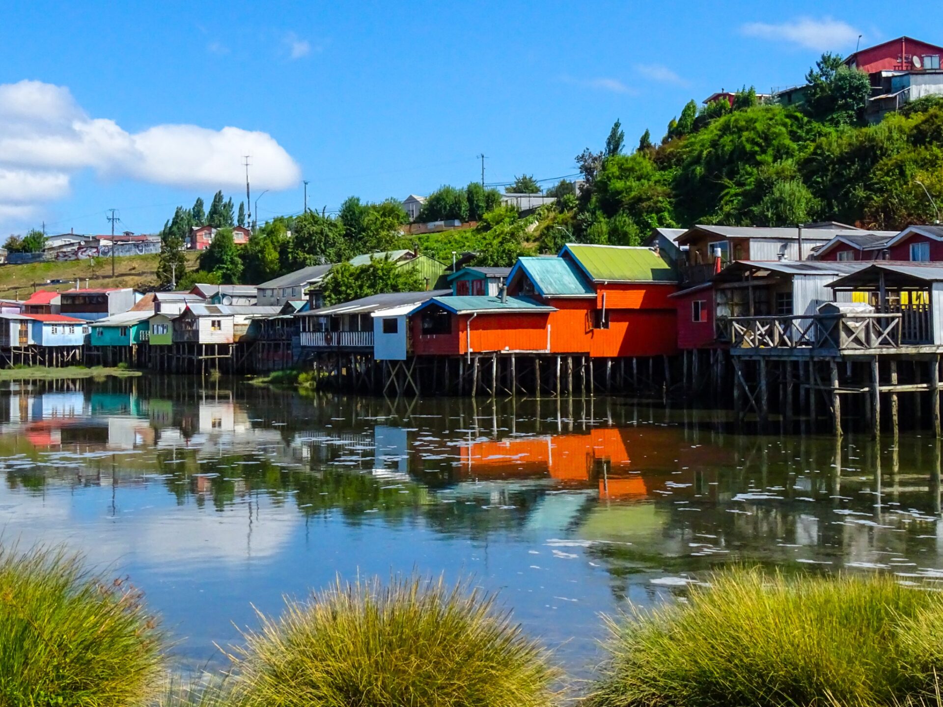 Colorful palafitos reflected in calm water in Castro, Chiloé, Chile