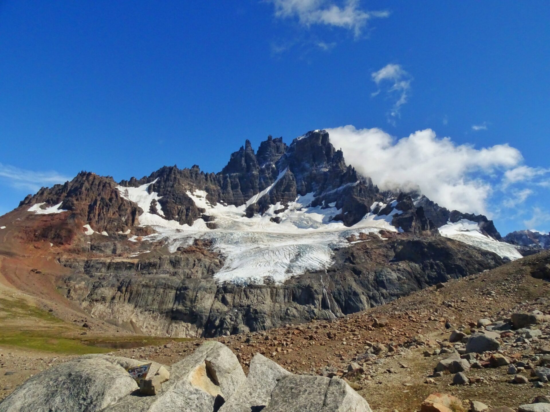 Cerro Castillo peaks rising above rocky terrain and glacier-covered slopes beneath a clear mountain sky.