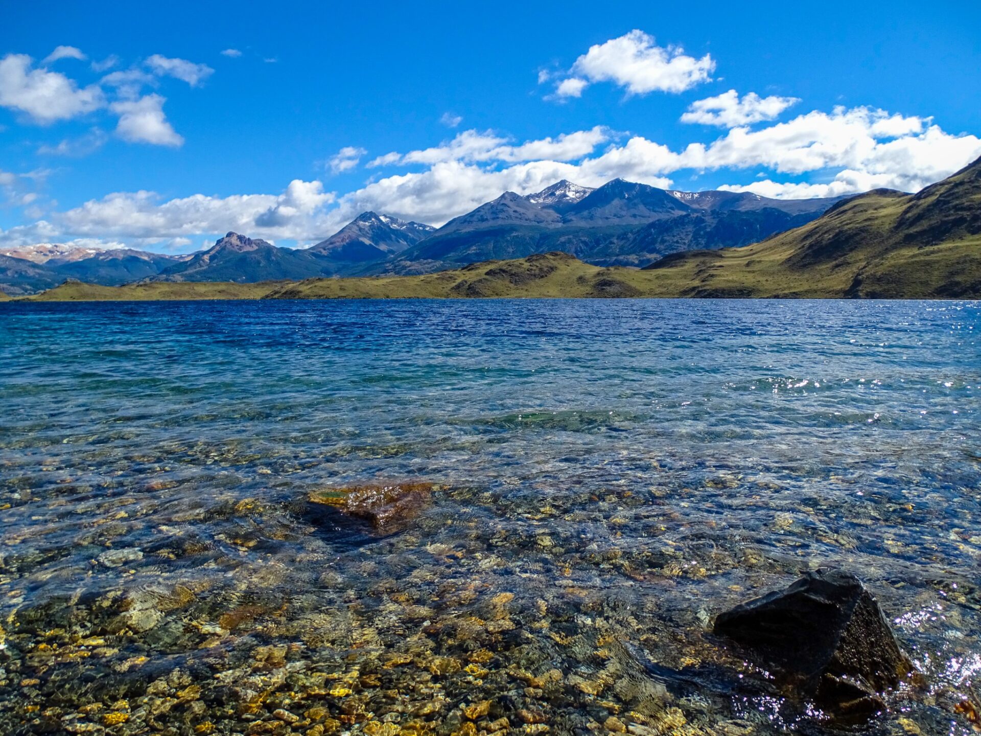 Crystal-clear waters of Lago Gutiérrez with mountain peaks rising beyond the shoreline.